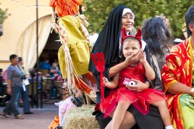 A mother and daughter ride the “Haunted Hay Ride” through Town Square on Halloween Monday, Oct. 31, 2011